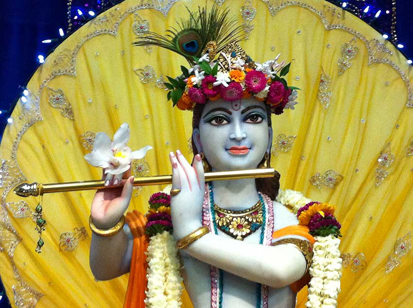 Krishna deity in white marble with flute, peacock feather and effulgence
