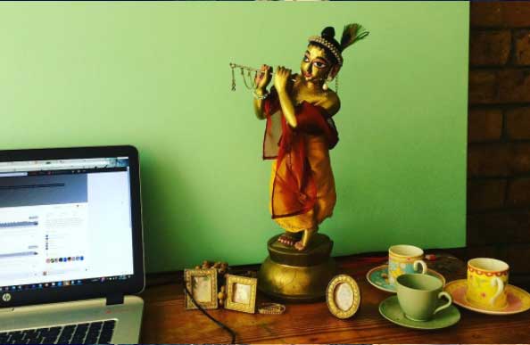 deity on my work desk with little photo frames Krishna deity while I work looking lovingly at me