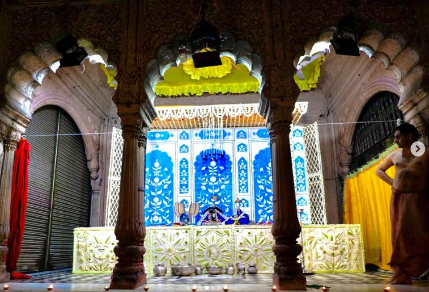 overview of shri radhraman temple with indigo blue altar backdrop and temple arches