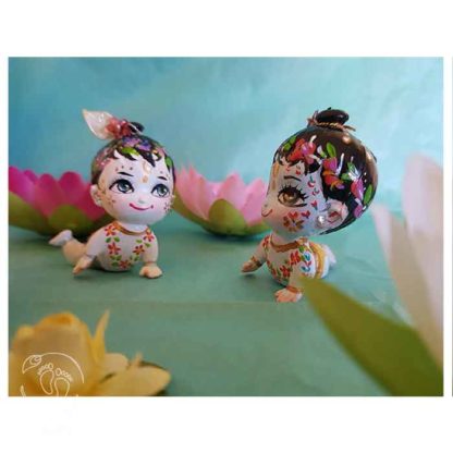 krishna balaram crawling dolls on a turquoise background with lotus flowers
