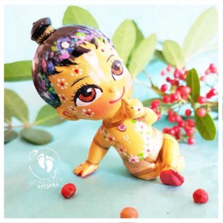 baby Nimai sitting on turquoise background with red berries and leaves and flower garland flower crown and beautiful ornaments