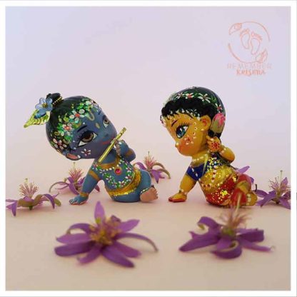 krsna plays flute krishna doll radha doll holds lotus flower and looks at krsna doll