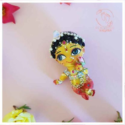 radharani doll with crown and beautiful garments holding lotus blossom