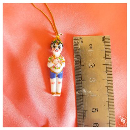 Rememer Krishna and Balaram pendant standing doll of Balaram measures 1 half inch tall on gold chain and peach background