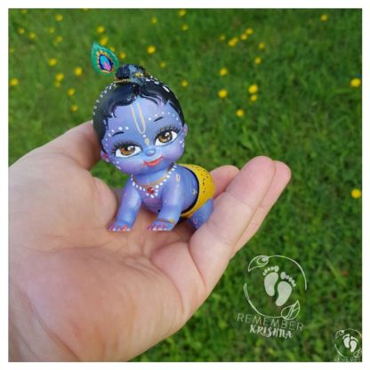 Krishna doll on his knees