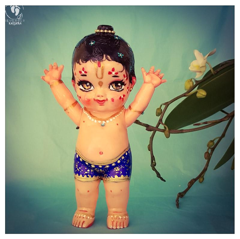 standing balaram doll with his arms in the air
