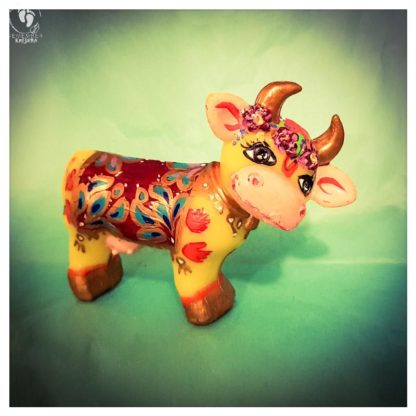 little cow krishnas friend handprints decorated blanket golden horns and flowers friendly face