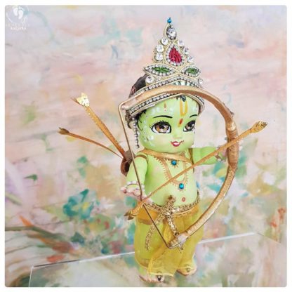 Rama doll for sale lord rama dolls with green skin and golden bow, a golden quiver and a golden arrow strung to rama bow. on a muted peach background. Hindu Vaishnava ramayan interest