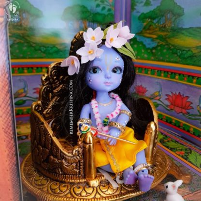 krsna doll sitting in throne room with flower crown garland and bunny