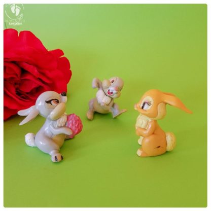 Krishna bunny rabbit friends toys on a green background with red fake roses