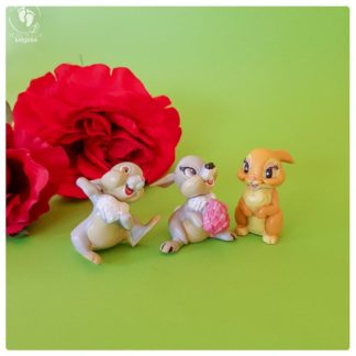 Krishna bunny rabbit friends toys on a green background with red fake roses