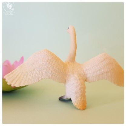 swan toy plastic doll with spread wings and lotus flower in background on aquamarine colored cardboard for sale