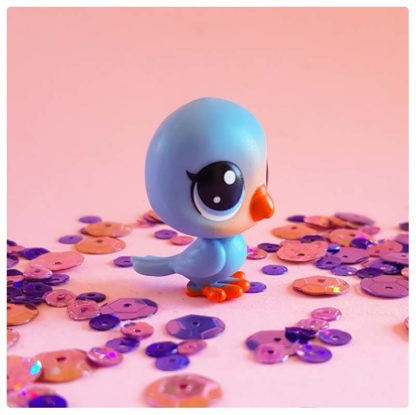 rosy little blue bird on a pink background of sequins