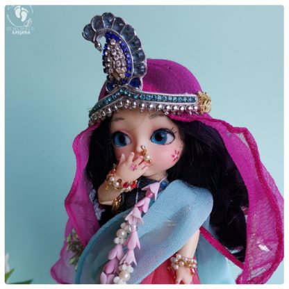 Lavanya Radha doll with pink dupatta blue garments and delicate garland on blue background