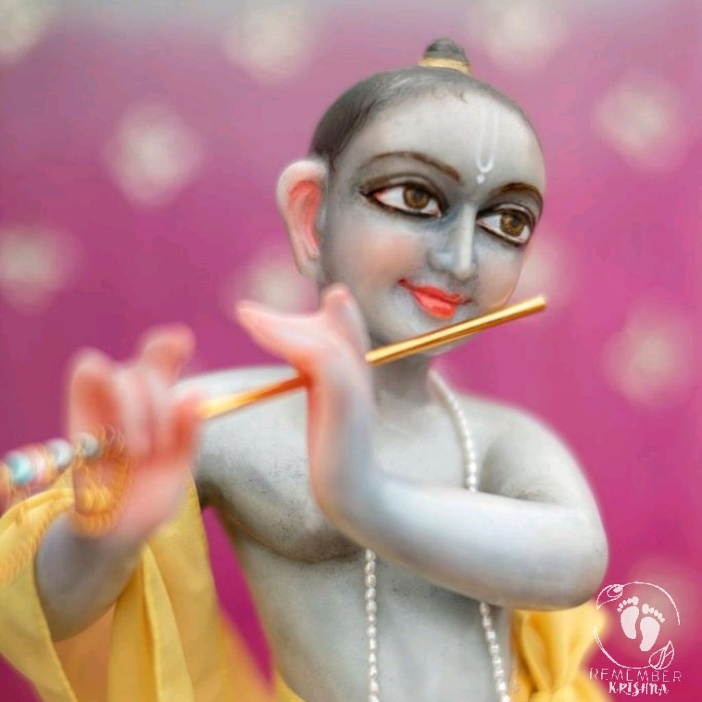 Krishna deity beautiful blue marble dark eyed lord with flute and 18 inch marble body murti made on pink background wearing yellow clothes