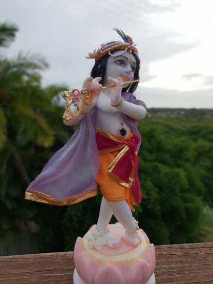 12 inch Krishna murti in white marble painted and garmented with shrinigar against natural background deity of kahna