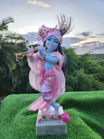 Mohana krishna deity blue deity of Krishna dressed in yellow garments with a red turban and peacock feather in his hair and playing the flute red velvet cloak and red velvet