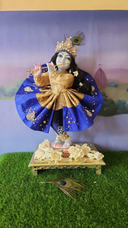 Mohana krishna deity blue deity of Krishna dressed in yellow garments with a red turban and peacock feather in his hair and playing the flute red blue fancy vrindavanchandra outfit