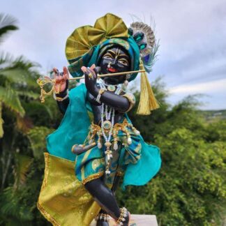 deity black marble form of lord krishna murti radha kanta wearing peacock coloured garments and holding a flute