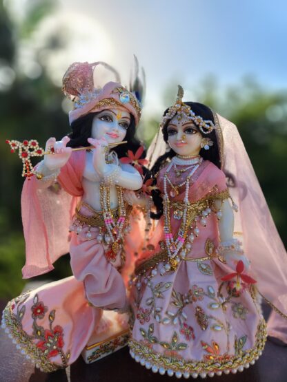 Full shot of Radha and Krishna standing together, highlighting their contrasting outfits and postures.