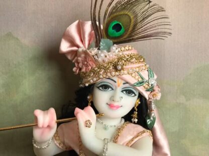 Quality white marble krishna deity hand carved Kamal Nayana weearing soft pink outfit with delicate pink hands in a pink turban and a peacock feather with delicate pearl and gold jewelery 12inch tall deity of Krishna shown holding flute