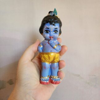 Little Krishna doll held in hand