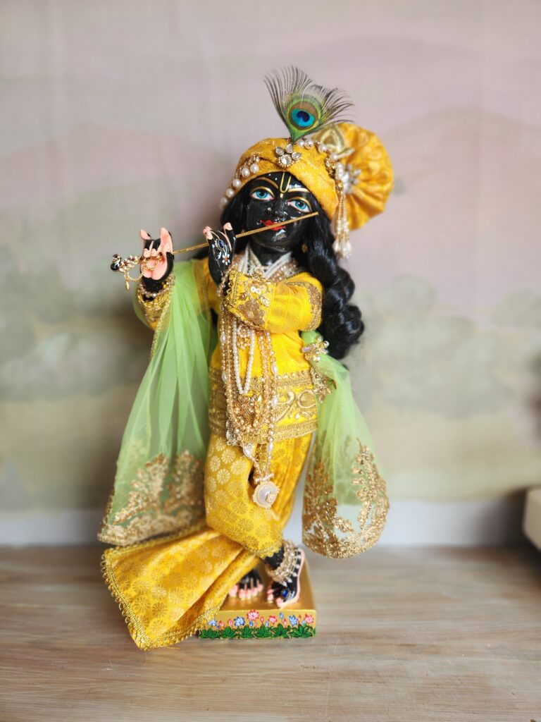 Syamasundar black marble deity of krishna 18 inch tall vigraha wearing yellow opulent outfit and a yellow pagri