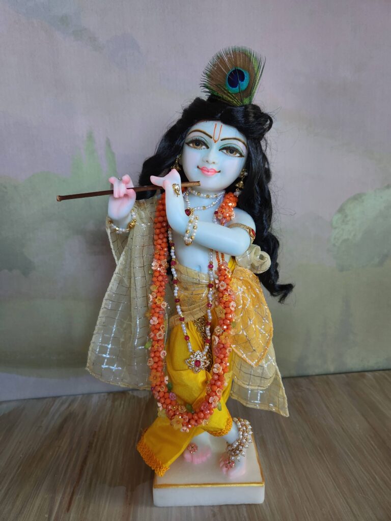 Krishna deity wearing a flowery marigold inspired jewelled garland