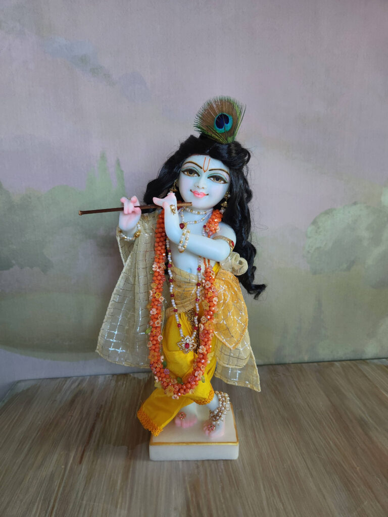 Krishna deity wearing a flowery marigold inspired jewelled garland