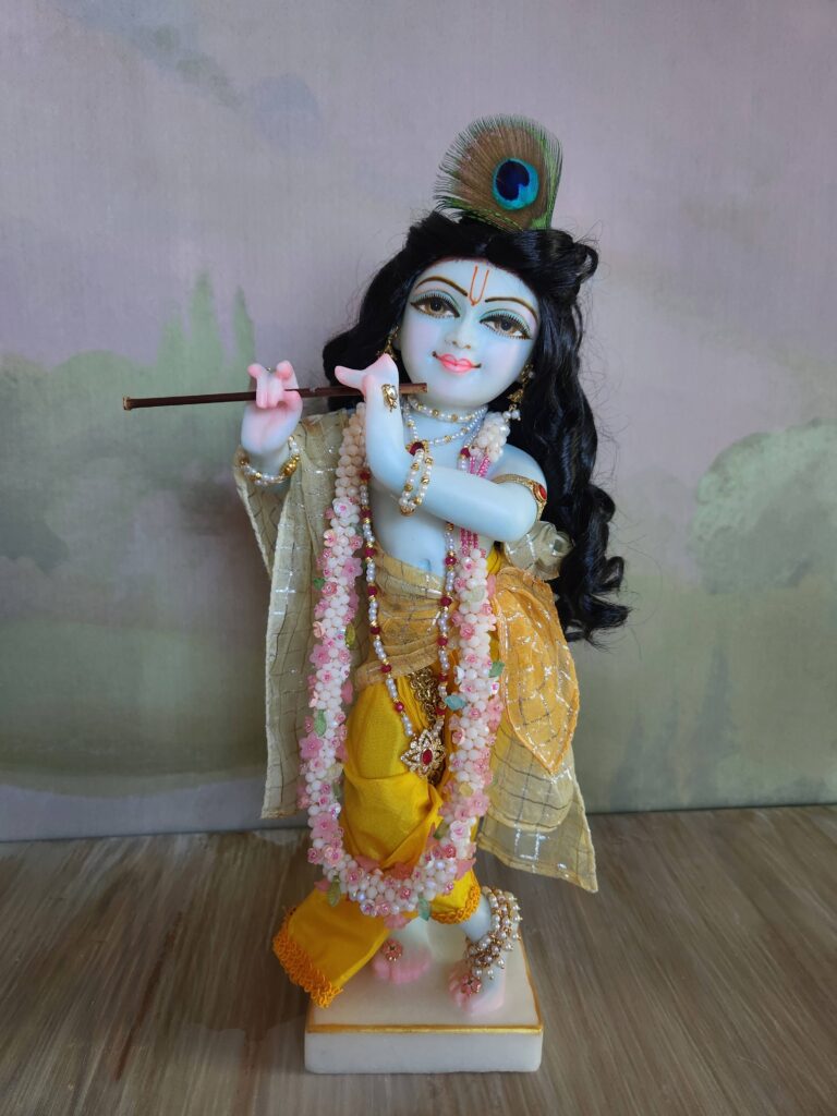 Krishna deity shown wearing flowery jewelled mala in rose and jasmine colorways.