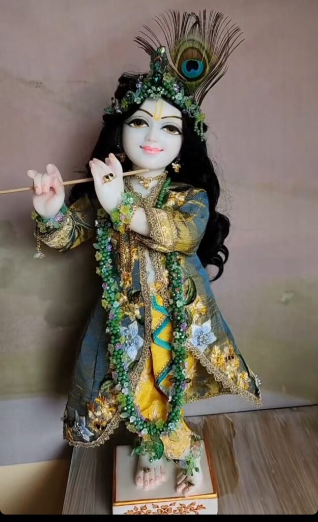 Krishna deity exquisitely adorned with full flowery garlands