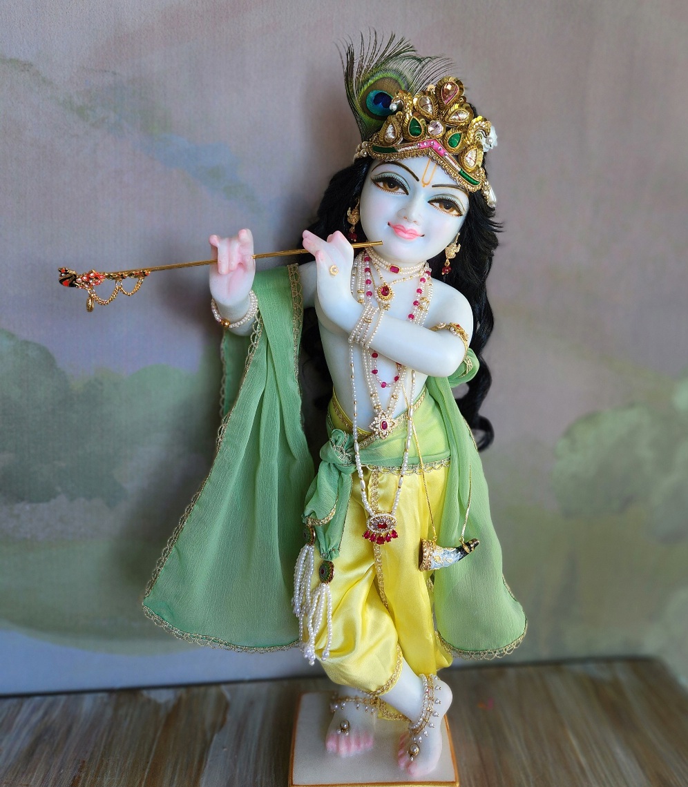 sweet Krishna deity hand carved white marble tinted gentle blu wearing yellow and green