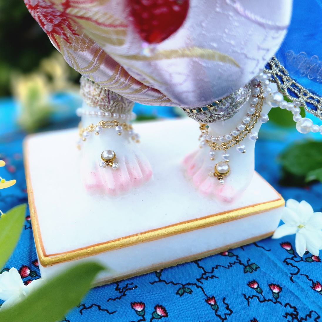 close up of Krishna deity feet wearing jewellery