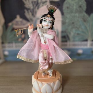 balgopal deity of krishna carved in white marble with a lotus base. dressed in delicate pink shringar