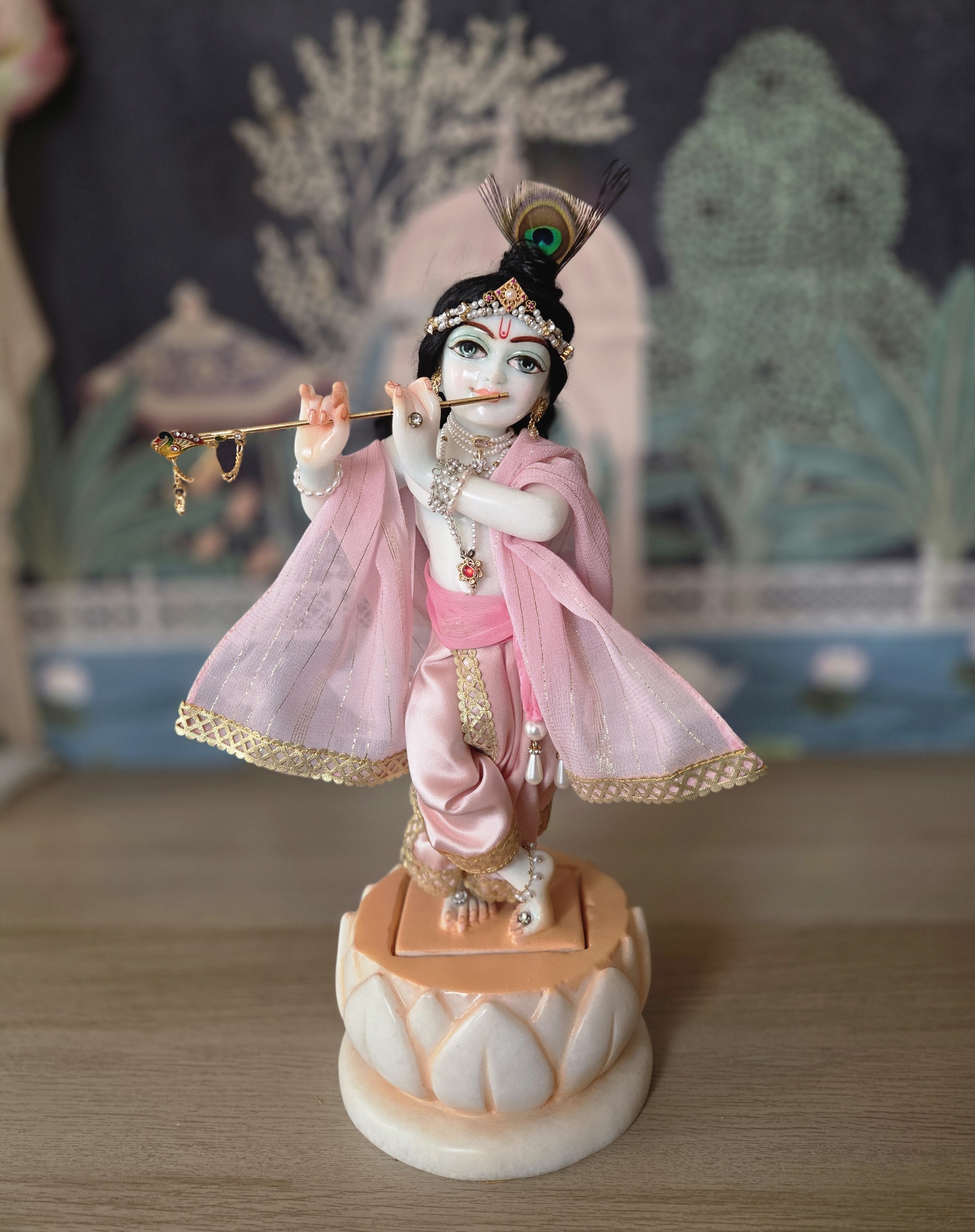 balgopal deity of krishna carved in white marble with a lotus base. dressed in delicate pink shringar