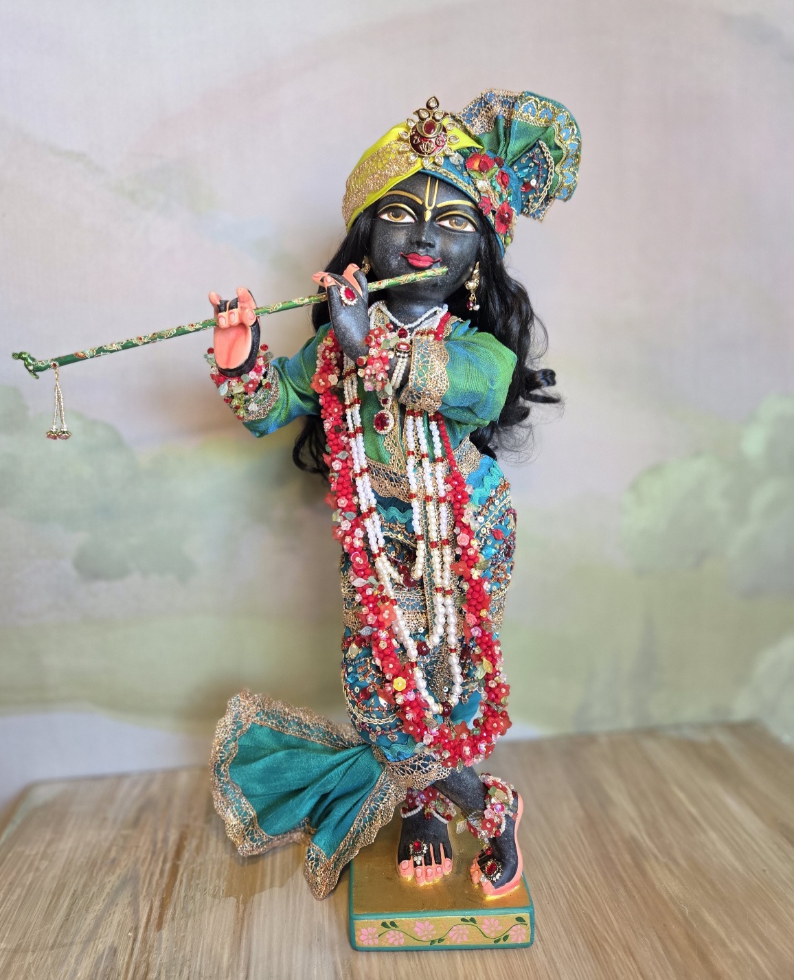 Luxurious black Marble deity of Gopinath Krishna standing with flute to His nectarian lips. Gopinath a hand-carved black marble Krishna deity, 18 inches tall, with 7 outfits & flower-jewel shringar included. One of a kind — free shipping. Dressed in citrine yellow and kingfisher blue green with garlands of everfresh flowers and pearl jewelery