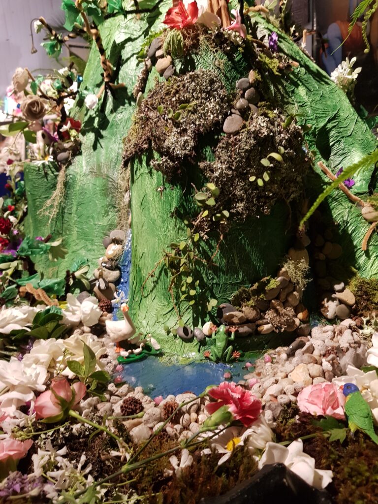 close up view of goverdhan made from papier mache and fresh flowers