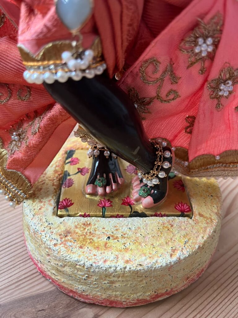 Close up of KrishnaKantha lotus feet displaying the base made of cement which the murti inserts into for stability